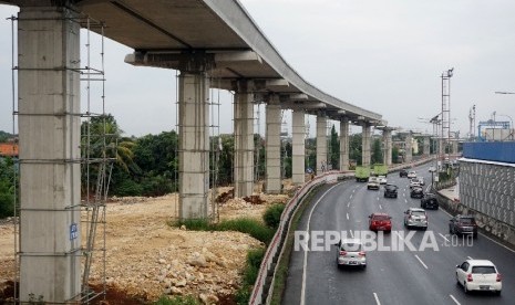 Kendaraan melintas di samping proyek infrastruktur transportasi massal kereta ringan atau Light Rail Transit (LRT) di kawasan Halim, Jakarta, Jumat (30/6). 