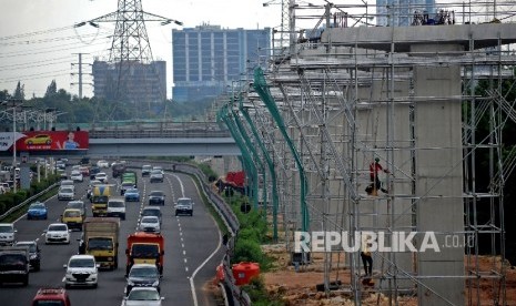 Kendaraan melintas di samping proyek pembangunan tiang penyangga jalur transportasi Light Rail Transit (LRT) rute Cibubur-Cawang di kawasan Halim, Jakarta, Selasa (7/2)