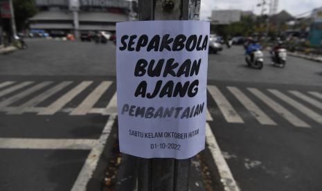 MUI Doakan Korban Tragedi Kanjuruhan. Foto:  Kendaraan melintas di samping selebaran yang tertempel di fasilitas umum, Kota Malang, Jawa Timur, Senin (3/10/2022). Selebaran tersebut berisi kecaman dan tuntutan agar tragedi yang terjadi di Stadion Kanjuruhan segera diusut tuntas.