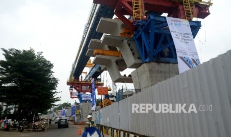 Kendaraan melintas di sekitar proyek kereta ringan atau LRT rute Kelapa Gading- Rawangun yang sudah memulai pemasangan beton box girder, Jakarta, Selasa (30/5).