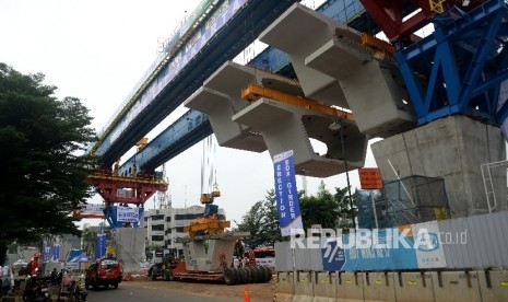 Kendaraan melintas di sekitar proyek kereta ringan atau LRT rute Kelapa Gading- Rawangun yang sudah memulai pemasangan beton box girder.