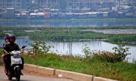 Kendaraan melintas di tepi Waduk Pluit, Jakarta Utara.