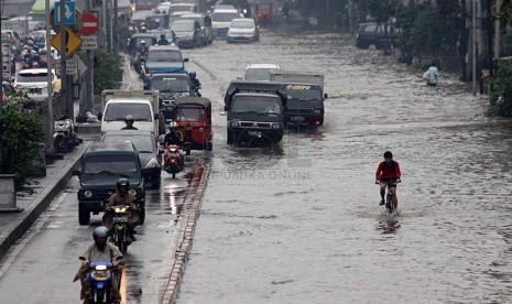 Kendaraan melintasi banjir yang merendam jalan Gunung Sahari, Jakarta Pusat, Kamis (27/2).     (Republika/Yasin Habibi)