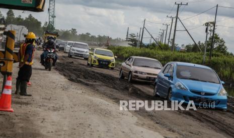 Kendaraan melintasi jalan rusak di Jalan Trans Kalimantan Bukit Rawi, Pulang Pisau, Kalimantan Tengah, Kamis (16/12/2021). Jalur nasional Kalimantan poros tengah yang merupakan penghubung Kota Palangkaraya dengan sejumlah kabupaten di Kalteng tersebut rusak dan berlubang setelah diterjang banjir luapan Sungai Kahayan dan Sungai Rungan selama tiga pekan.