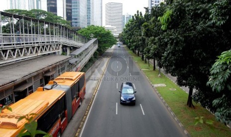   Kendaraan melintasi Jalan Sudirman yang lengang, Jakarta Pusat, Jumat (18/4). (foto : Raisan Al Farisi)