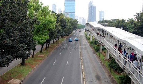   Kendaraan melintasi Jalan Sudirman yang lengang, Jakarta Pusat, Jumat (18/4). (foto : Raisan Al Farisi)