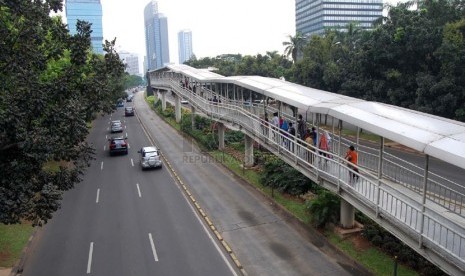   Kendaraan melintasi Jalan Sudirman yang lengang, Jakarta Pusat, Jumat (18/4). (foto : Raisan Al Farisi)