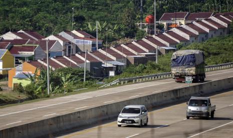 Kendaraan melintasi Jalan Tol Batang berlatar belakang kawasan rumah subsidi di Kabupaten Batang, Jawa Tengah, Jumat (18/6). BI juga melanjutkan pelonggaran rasio Loan to Value (LTV) atau Financing to Value (FTV) Kredit atau Pembiayaan Properti menjadi paling tinggi 100 persen.