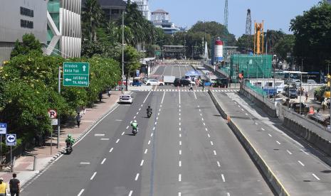 Kendaraan melintasi jalan yang lengang akibat penyekatan yang dilakukan polisi terkait aksi reuni 212 di Jalan MH Thamrin, Jakarta Pusat, Kamis (2/12/2021). 