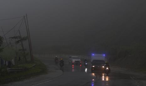 Kendaraan melintasi jalan yang tertutup kabut di Jalur Trans Sulawesi Kawasan Pegunungan Kebun Kopi di Kabupaten Parigi Moutong, Sulawesi Tengah, Sabtu (30/4/2022). Pemudik diimbau hindari perjalanan malam hari agar tak menghadapi cuaca buruk.