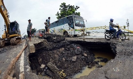 Kendaraan melintasi jalur Pantura yang ambles di Desa Mandalawangi, Ciasem, Subang, Jawa Barat.