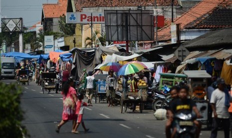 Kendaraan melintasi pasar tumpah yang berpotensi menimbulkan kemacetan saat arus mudik. (Ilustrasi)