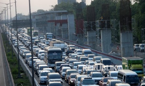 Kendaraan melintasi tol Jakarta-Cikampek disamping pembangunan Light Rail Transit (LRT) di kawasan Jatibening, Bekasi, Jabar, Ahad (8/10).