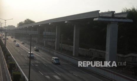 Kendaraan melintasi tol Jakarta-Cikampek disamping pembangunan Light Rail Transit (LRT) di kawasan Jatibening, Bekasi, Jabar, Ahad (8/10). 