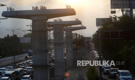 Kendaraan melintasi tol Jakarta-Cikampek disamping pembangunan Light Rail Transit (LRT) di kawasan Jatibening, Bekasi, Jabar, Ahad (8/10).