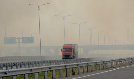 Kendaraan menerobos kabut asap akibat kebakaran lahan di tol Palembang-Indralaya, Sumatera Selatan, Rabu (7/8/2019). 