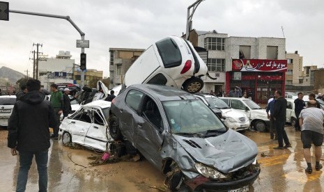 Kendaraan menumpuk di jalan akibat banjir bandang di Shiraz, Iran, Senin (25/3).