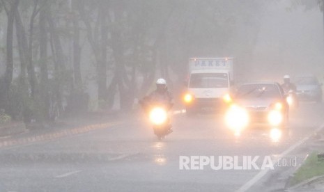 Pengendara menyalakan lampu karena pendeknya jarak pandang saat hujan deras (ilustrasi)