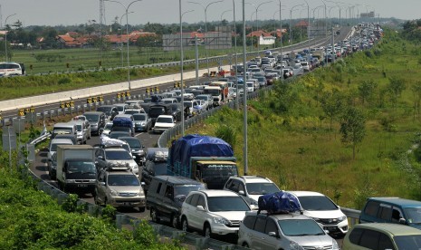 Kendaraan pemudik antre menuju gerbang exit tol Pejagan-Brebes Timur, Jawa Tengah, Sabtu (2/7). Puncak arus mudik pada H-4 Lebaran volume kendaraan yang melintas tol meningkat dibandingkan H-5 dan mengakibatkan kemacetan panjang di pintu keluar tol tersebu