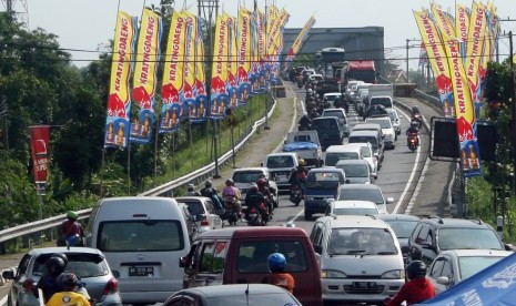 Kendaraan pemudik terjebak kemacetan di jembatan Kertosono, Nganjuk, Jawa Timur, Ahad (27/7).