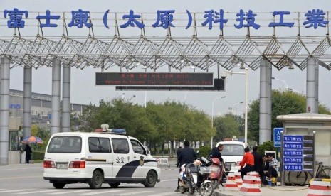  Kendaraan polisi diparkir depan pintu masuk pabrik Foxconn Tech-Industri Park di Taiyuan, provinsi Shanxi, Senin (24/9). (Reuters)