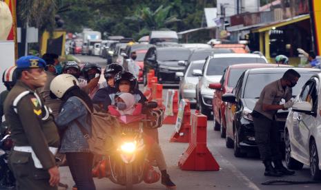 Kendaraan roda empat antre memasuki kota saat masa PSBB, di Posko Perbatasan Kayukalek, Padang, Sumatera Barat, Selasa (26/5/20). Pasca libur Lebaran, banyak kendaraan terutama roda empat yang masuk ke kota Padang karena habis berlebaran dari luar kota seiring dengan kembali bekerjanya PNS di kota itu, namun tetap dilakukan pemeriksaan sesuai aturan PSBB.