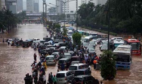 Kendaraan terjebak banjir yang menggenangi kawasan Jalan Sudirman, Jakarta, Kamis (17/1). 