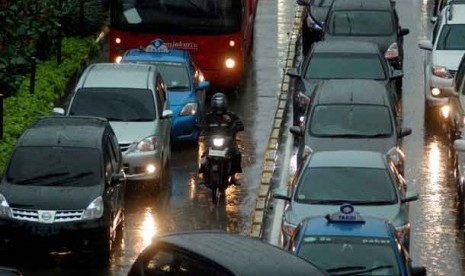 Kendaraan terjebak kemacetan ketika hujan deras mengguyur kawasan Jalan Thamrin, Jakarta, Jumat (21/12). 