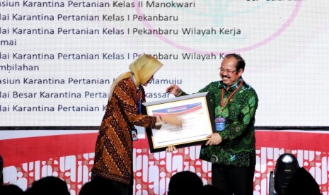 Kepala Badan Karantina Pertanian Kementerian Pertanian Banun Harpini (kiri) saat menerima penghargaan dari Ombudsman RI di Hotel Borobudur, Jakarta, Rabu (7/12).