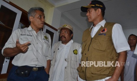 Kepala Badan Nasional Penanggulangan Bencana (BNPB) Doni Monardo (kanan) berbincang dengan Kepala Bidang Mitigasi Gunung Api Kristanto (kiri) didampingi staf saat berkunjung ke pos pengamatan Gunung Anak Karakatau (GAK), Anyer, Serang, Banten, Sabtu (12/1/2019).