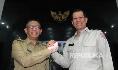 Kepala Badan Nasional Penanggulangan Bencana Daerah (BNPB) Doni Monardo (kiri) berjabat tangan dengan Gubernur Kalimantan Barat Sutarmidji saat rapat koordinasi penanganan kebakaran hutan dan lahan (karhutla) di Pontianak, Kalimantan Barat, Senin (5/8/2019).