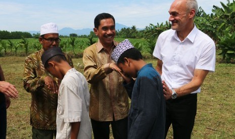 Kepala Badan Nasional Penanggulangan Terorisme (BNPT) Komjen Pol Suhardi Alius (tengah) dan pendiri Pesantren Al Hidayah yang merupakan mantan terpidana kasus terorisme Khairul Ghazali (kiri), mendampingi Wakil Presiden Bundeskriminalamt (BKA) Jerman Michael Kretschmer (kanan), menyalami santri yang merupakan anak mantan teroris saat melakukan kunjungan, di Deli Serdang, Sumatera Utara, Rabu (11/7). 