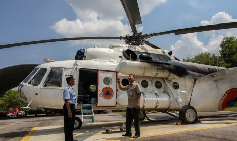 Kepala Badan Penanggulangan Bencana Daerah (BPBD) Provinsi Riau Edward Sanger (kanan) didampingi Kadisops Lanud Roesmin Nurjadin Kol Pnb Jajang Setiawan (kiri) meninjau kesiapan Helikopter Water Bombing di Pekanbaru, Riau, Senin (29/7/2019). 