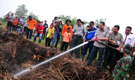 Kepala Badan Penanggulangan Bencana Nasional (BNPB) Willem Rampangilei mencoba memadamkan api yang ketika terjadi kebakaran di lahan gambut Rimbo Panjang Kabupaten Kampar, Riau, Rabu (9/9). 