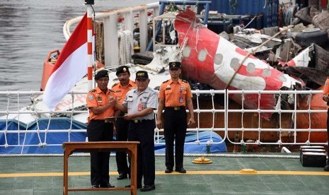  Kepala Basarnas Marsekal Madya TNI FH Bambang Soelistyo (kiri) salam komando dengan Ketua KNKT Tatang Kurniadi (kedua kanan) ketika serah terima badan pesawat Airasia QZ8501 di Pelabuhan Tanjung Priok, Jakarta Utara, Senin (2/3). (Antara/Zabur Karuru)