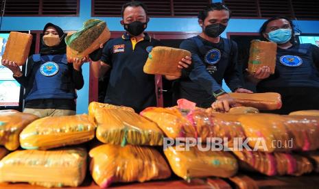 Kepala Bidang Pemberantasan Badan Narkotika Nasional (BNN) Provinsi Jambi Guntur Aryo Tejo (kedua kiri) didampingi petugas menunjukkan barang bukti paketan ganja kering saat rilis kasus di Kantor BNN Provinsi Jambi, Jambi, Senin (4/10/2021). BNN Provinsi Jambi menggagalkan pengiriman narkotika jenis ganja kering seberat 45 kilogram asal Aceh tujuan Pulau Jawa di Jalan Lintas Tengah Sumatera, Bungo dan mengamankan seorang tersangka. 