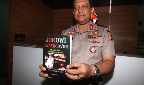 Kepala Biro Penerangan Masyarakat Divisi Humas Polri Brigjen Pol Rikwanto menunjukkan buku 'Jokowi Undercover' usai memberikan keterangan pers di Jakarta, Selasa (3/1).