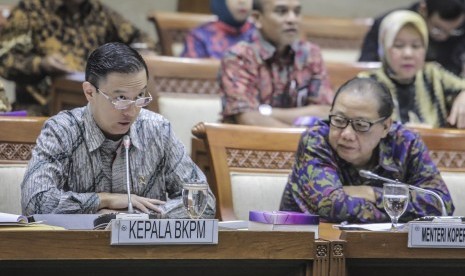 Kepala BKPM Thomas Lembong (kiri) bersama Menteri Koperasi dan UKM Anak Agung Gede Ngurah Puspayoga (kanan) memberikan paparannya pada Rapat Kerja dengan Komisi VI DPR di Komplek DPR, Jakarta, Rabu (18/7).