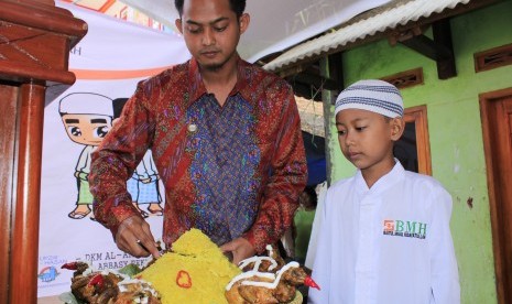 Kepala BMH Perwakilan Jabar Zainal Abidin tengah memotong tumpeng dalam acara sunatan massal anak yatim dan dhuafa, belum lama ini. 