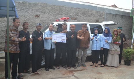 Kepala BPJS Kesehatan Cabang Utama Bandung dr Herman Dinata Mihardja AAAk (keempat dari kiri) menyerahkan secara simbolik kelengkapan mobil ambulans di RW 01, Kelurahan Cigending, Kecamatan Ujungberung, Kota Bandung, Kamis (15/12).  