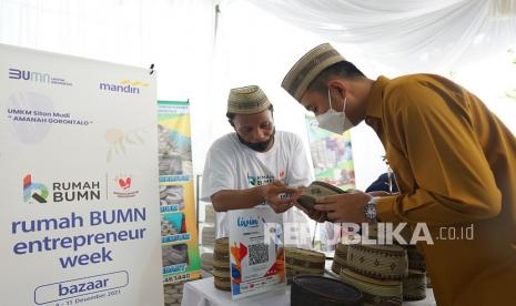 Kepala Cabang Bank Mandiri Gorontalo Darojat Wirabuana (kanan) melihat produk kerajinan tangan Upiah Karanji (kupiah keranjang) pada kegiatan Rumah BUMN Entrepreneur Week di halaman kantor Bank Mandiri, Kota Gorontalo, Gorontalo, Rabu (8/12/2021). Kegiatan tersebut memamerkan berbagai produk UMKM unggulan binaan Bank Mandiri mulai dari kuliner, kerajinan tangan dan fesyen. 