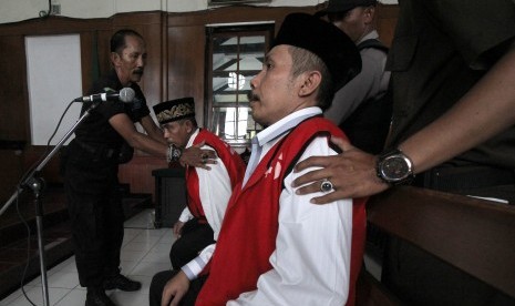 Kepala Desa Selo Awar-Awar Lumajang, Hariyono (kedua kanan) mengikuti sidang perdana kasus dugaan pembunuhan aktivis lingkungan Salim Kancil di Pengadilan Negeri (PN) Surabaya, Jawa Timur, Kamis (18/2). 