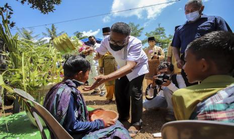 Kepala Dinas Kebudayaan dan Pariwisata (Disbudpar) Kota Batam Ardiwinata (kedua kiri) menyiramkan air kepada seorang anak saat kegiatan Tradisi Mandi Safar yang dilaksanakan setiap Rabu terakhir pada bulan Safar di Kampung Tua Terih, Batam, Kepulauan Riau, Rabu( 6/10/2021). Setelah tidak dilaksanakan selama dua tahun akibat pandemi COVID-19, tradisi Mandi Safar kembali dilaksanakan masyarakat setempat seiring menurunnya kasus COVID-19.