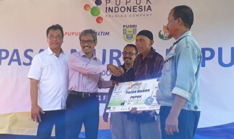    Kepala Dinas Perindustrian dan Perdagangan DIY Trisaktiyana bersama VP PKBL PT Pupuk Indonesia(Persero) Wahyu Supriyanto  dan Direktur SDM dan Umum PT Pupuk Sriwijaya Palembang Vov Indiarto menyerahkan secara simbolik bantuan pupuk murah kepada tiga petani dari Kabupaten Kulon Progo dan Bantul di Desa Cerme, Kecamatan Panjatan, Kabupaten Kulon Progo Sabtu (10/2).