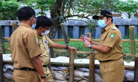 Kepala Dinas PUPR Kota Tangerang Decky Priambodo bersama Wali Kota Tangerang Arief Rachadiono Wismansyah meninjau tanggul buatan untuk mengantisipasi banjir di Kota Tangerang, Banten.