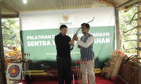 Kepala Divisi Pendistribusian dan Pendayagunaan BAZNAS, Efri S. Bahri secara simbolis menyerahkan bantuan perlengkapan lengkap alat memanah kepada seorang pengusaha Usaha Mikro Kecil dan Menengah (UMKM) di Kampung Wisata Panahan, Kelurahan Tanah Baru, Kecamatan Beji, Kota Depok, Jawa Barat. 