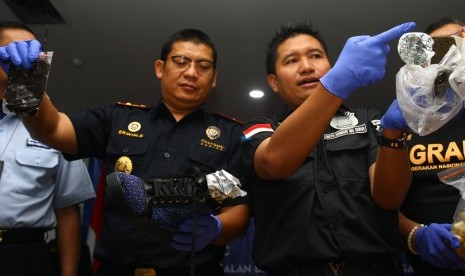 Kepala Kantor Bea Cukai Bandara Soetta Erwin Situmorang (kiri) bersama Kasat Narkoba Polres Bandara Kompol Raja M Silitonga (kanan) menunjukkan barang bukti narkoba yang berhasil ditegah dari seorang Warga Negara Rusia yang juga mantan tentara Rusia, saat jumpa pers di Kantor Bea Cukai Bandara Soekarno Hatta, Tangerang, Banten, Selasa (17/10). 