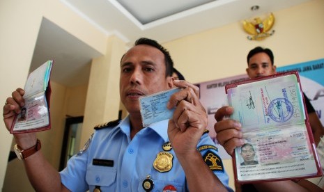 Kepala Kantor Imigrasi III Bekasi Is Edy Eko Putranto (kiri) didampingi jajarannya menunjukkan sejumlah barang bukti dokumen paspor dan KTP palsu calon haji yang gagal berangkat di Bekasi, Jawa Barat, Kamis (27/8).