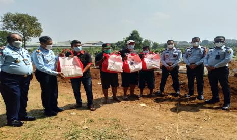 Kepala Kantor Wilayah Hukum dan HAM Jawa Barat Sudjonggo memberikan paket bantuan kepada penggali kubur TPU Pondok Rajeg yang berada di sekitaran Lapas Cibinong, Kabupaten Bogor, Kamis (29/7). 