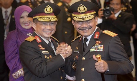 Kapolri Jenderal Polisi Tito Karnavian (kiri) berjabat tangan dengan pejabat Kapolri sebelumnya Jenderal Polisi Badrodin Haiti (kanan) seusai acara pelantikan yang dipimpin Presiden Joko Widodo di Istana Negara, Jakar